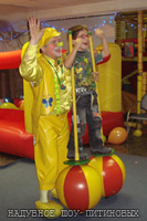 Дети ходят на надувных ходулях с клоуном Лимончиком